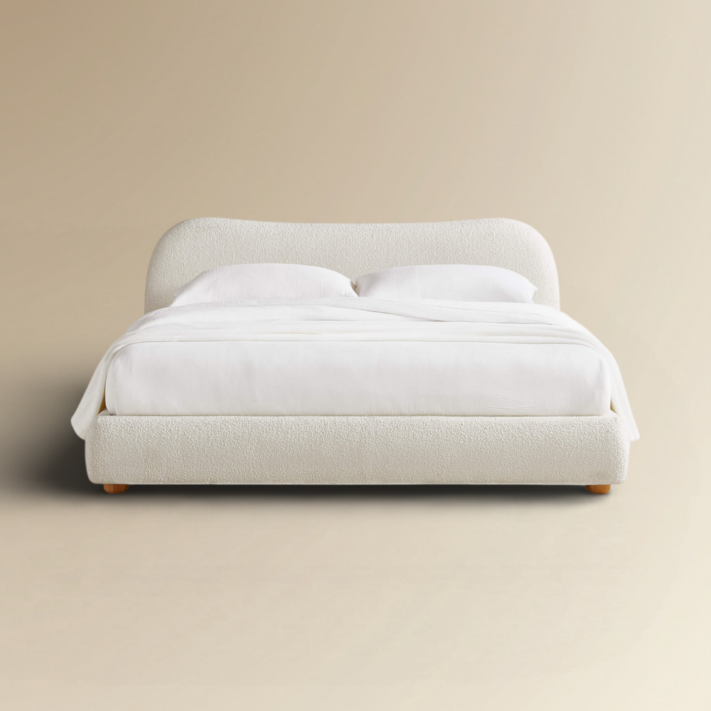 Carmel contemporary bouclé platform bed featuring a curved cream upholstered headboard and low-profile frame.