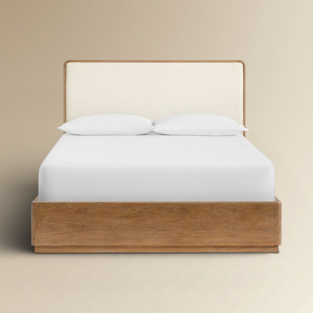 Dillon modern bouclé and oak wood platform bed with a cream upholstered headboard and natural timber frame.