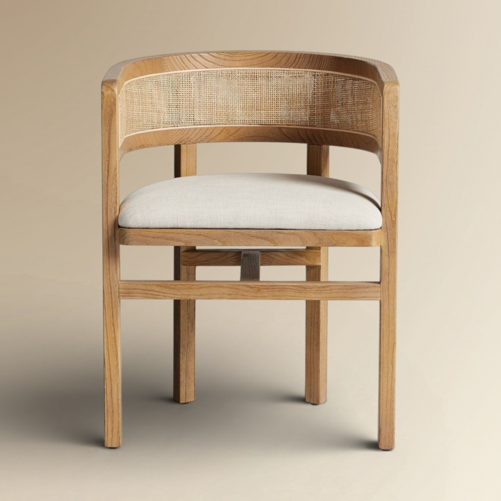 Emiliya dining chair featuring a curved oak frame, natural cane backrest, and cream upholstered seat.
